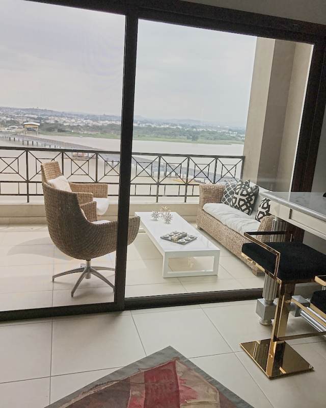 The terrace seen through the glass door, the river and the city beyond