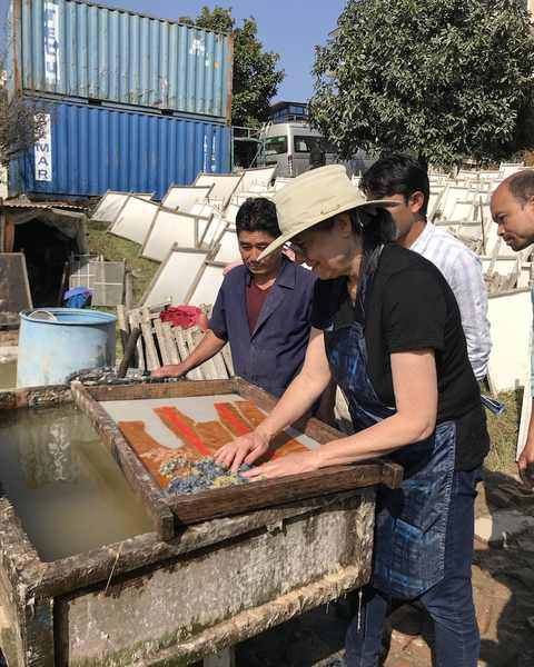 Jessica Stockholder placing coloured pulp and fibre onto a wet sheet in its mould