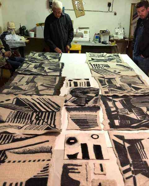 Black and white felt samples laid across a long workshop table