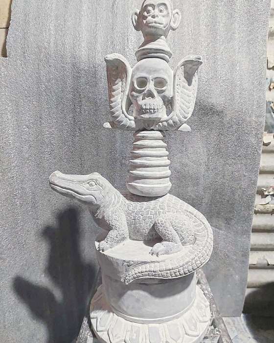 The finished sculpture seen from the front: monkey, skull between two cobras, ringed column, crocodile and lotus base