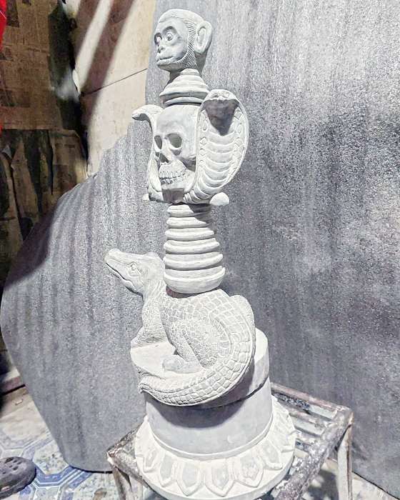 The finished sculpture seen from the side, showing the cobra hood and the crocodile’s scales