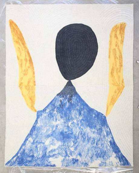 The finished felt: a black oval head, two yellow wings and a blue body