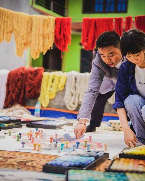 Aya Takano and the workshop master choosing wool colours over her drawing