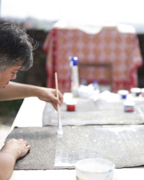 Vargas-Suárez Universal brushing medium onto a dark sheet of paper on a rooftop table