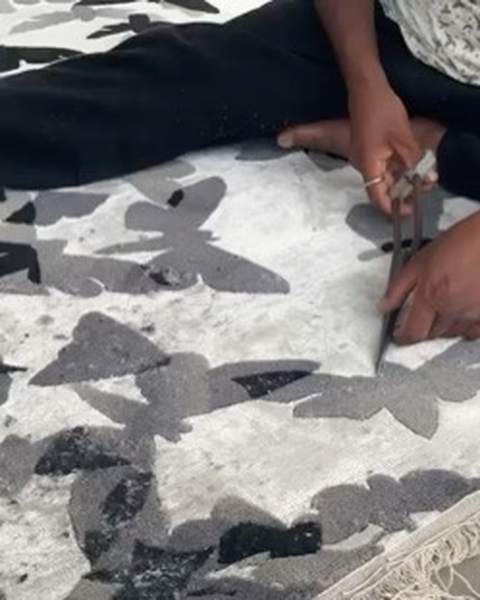 A carver seated on the work with long shears, black and grey butterflies around him
