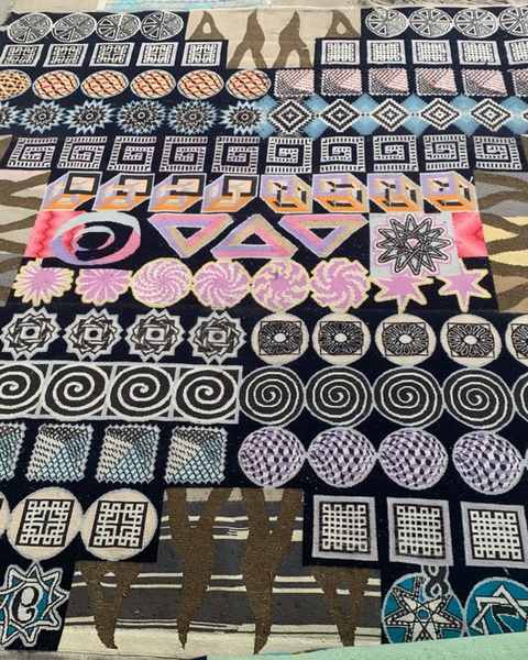 A finished hand-knotted work covered in rows of spirals, stars, mazes and impossible figures