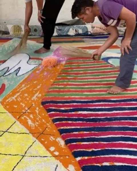 A worker brushing loose fibre off a striped red, blue and yellow work