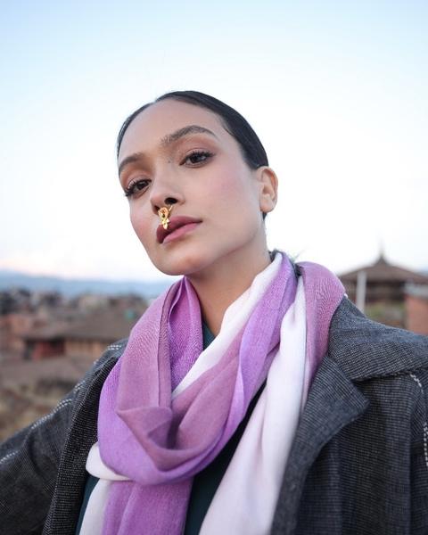 A model on a rooftop in a lilac and white scarf