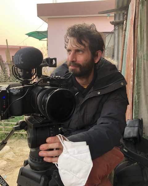 The director of photography behind a cinema camera on a tripod