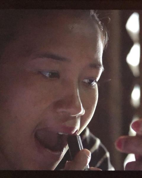 A frame from the film: a young woman lit by a window