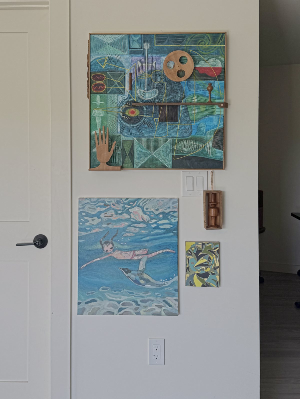 An entry wall with framed works hung close together