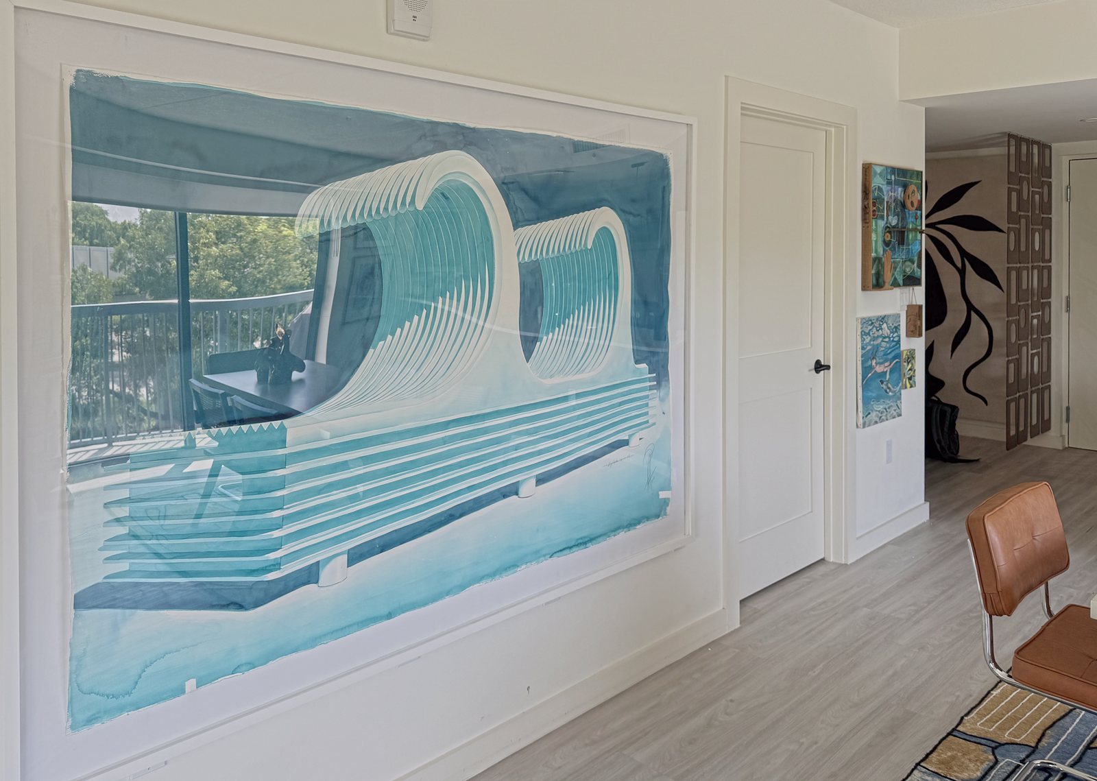 A large work on paper of a wave in blues, by the door