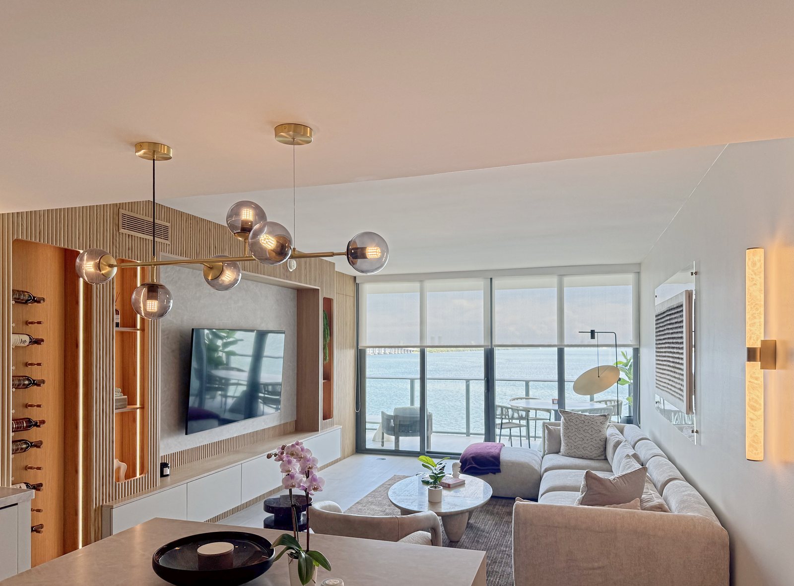Living room, fluted-oak wall and kitchen in one room, the bay beyond