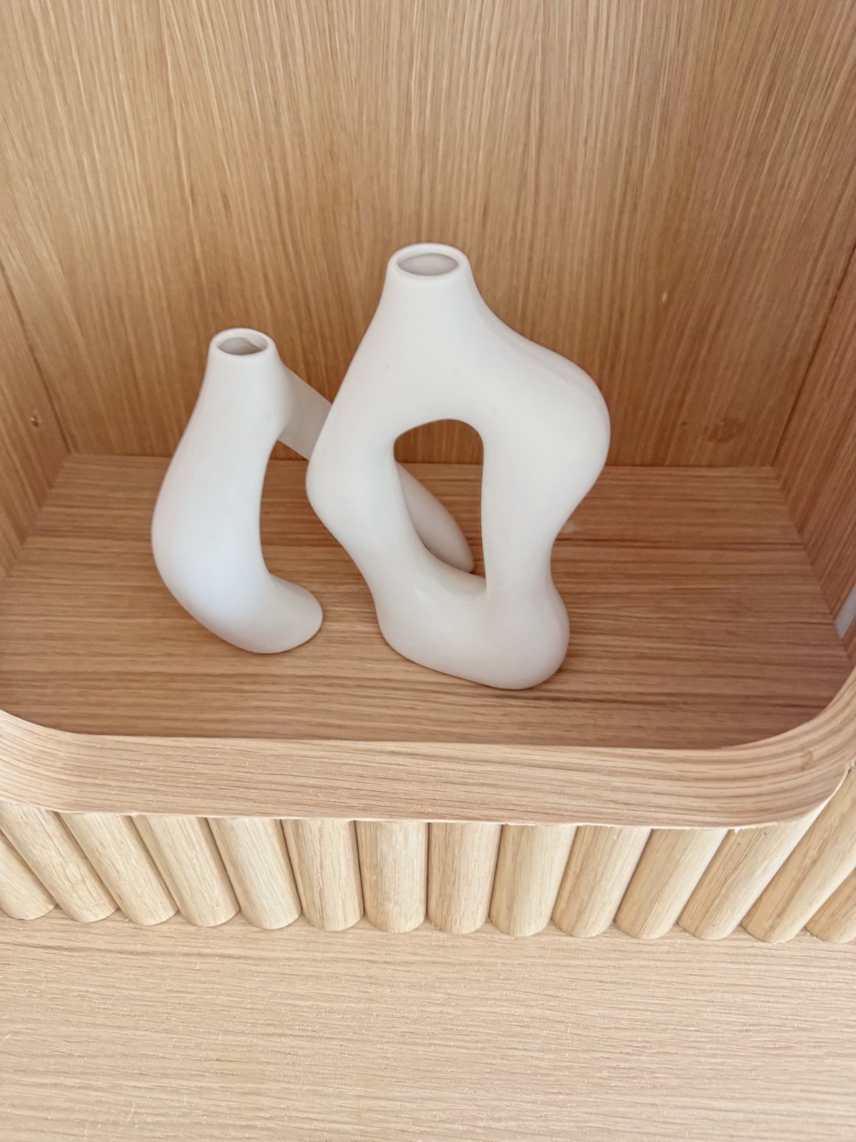 Two white ceramic vases in a fluted-oak niche