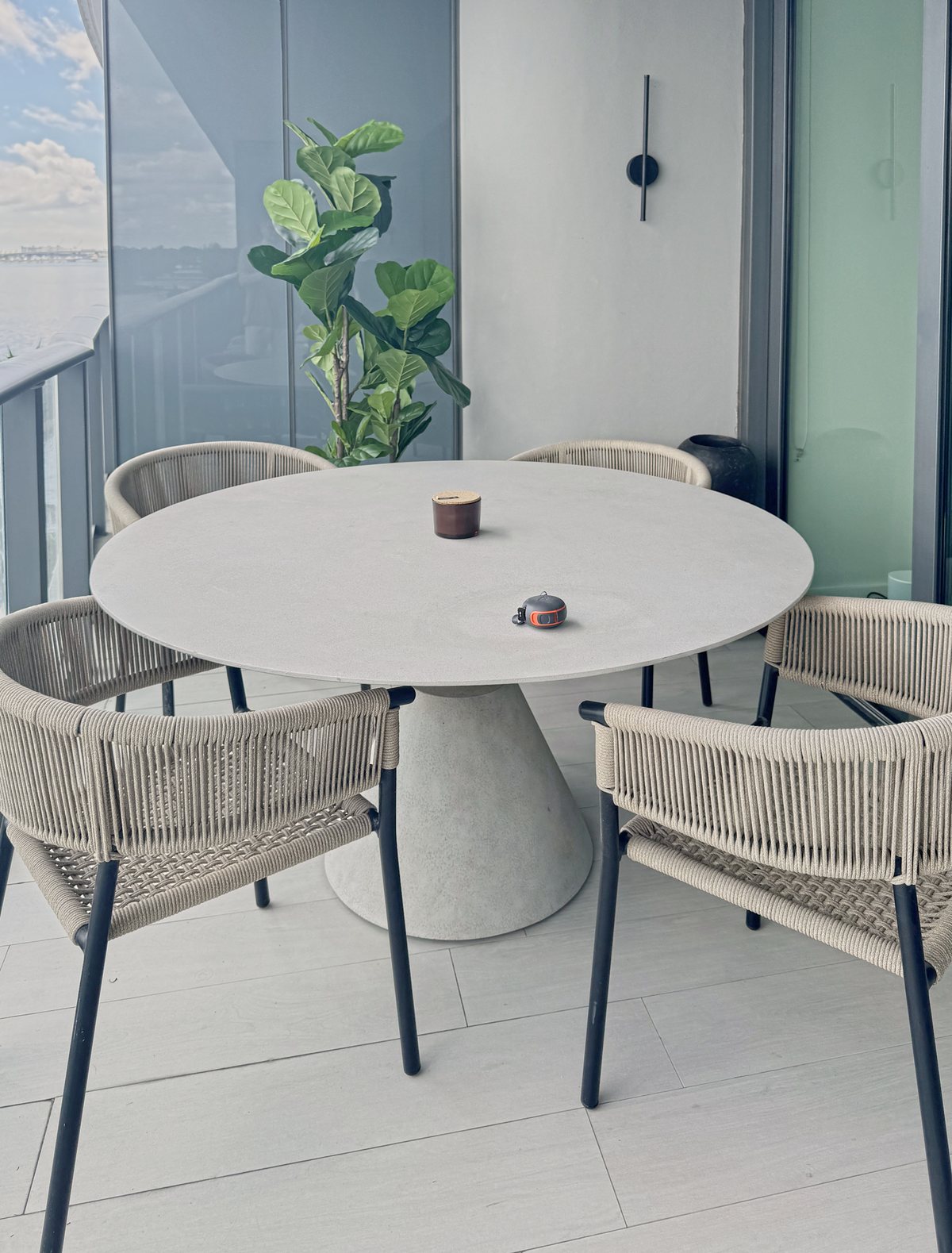 Terrace dining table in stone with woven chairs over the bay